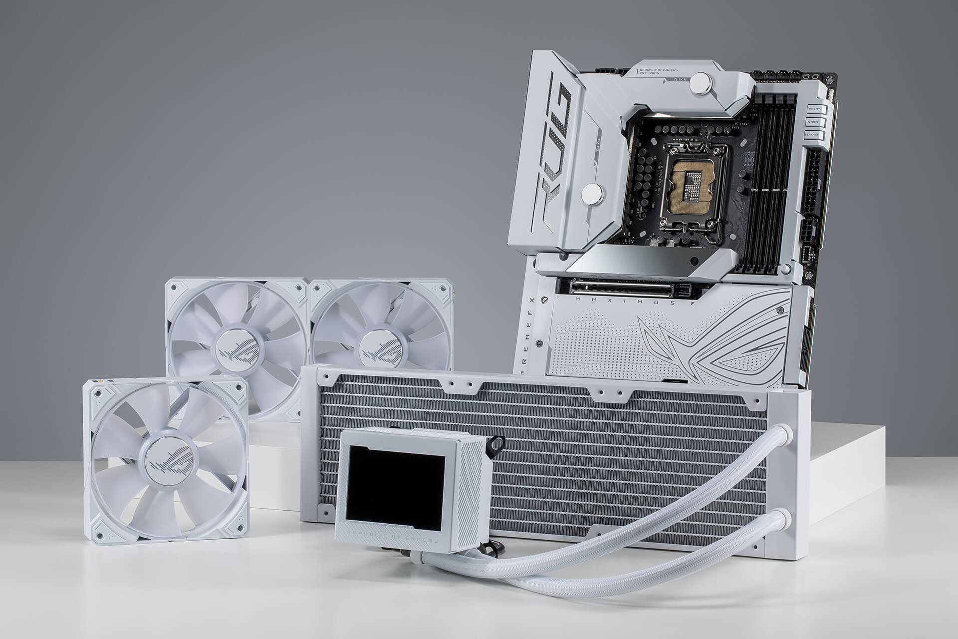 Vooraanzicht van de ROG Maximus Z790 Formula en de ROG Ryujin III 360 ARGB White Edition staand op een bureaublad.