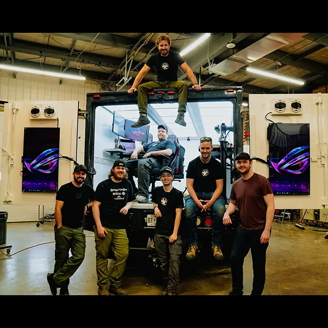 Hacksmith Industries team members posting for picture in front of the back of a truck