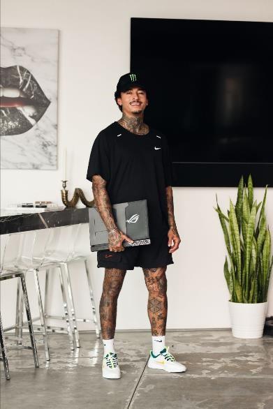Nyjah Huston standing and holding an ROG laptop