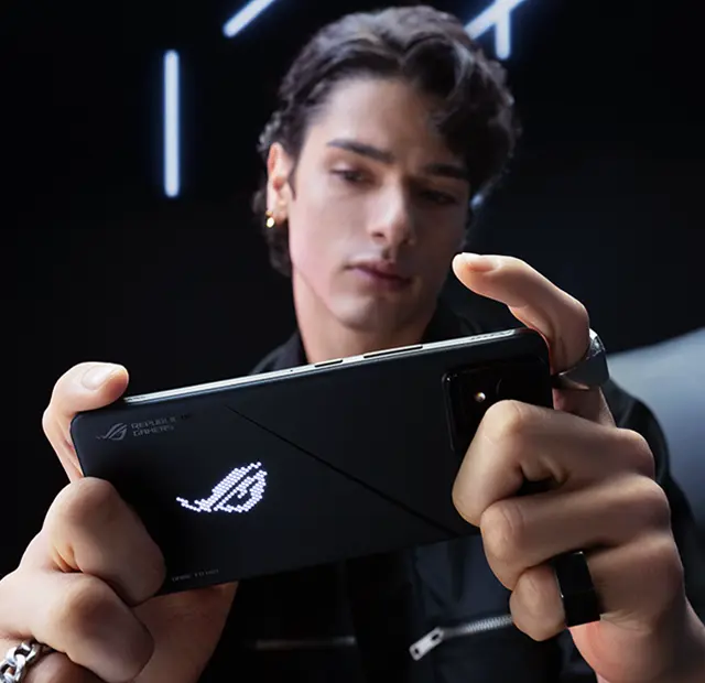 A picture of a professional gamer holding a ROG Phone 8 Pro horizontally and playing mobile game.