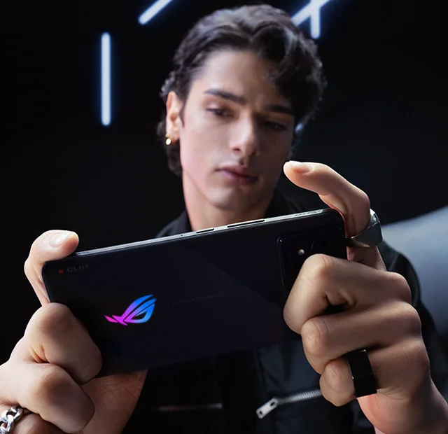 A picture of a professional gamer holding a ROG Phone 8 horizontally and playing mobile game.
